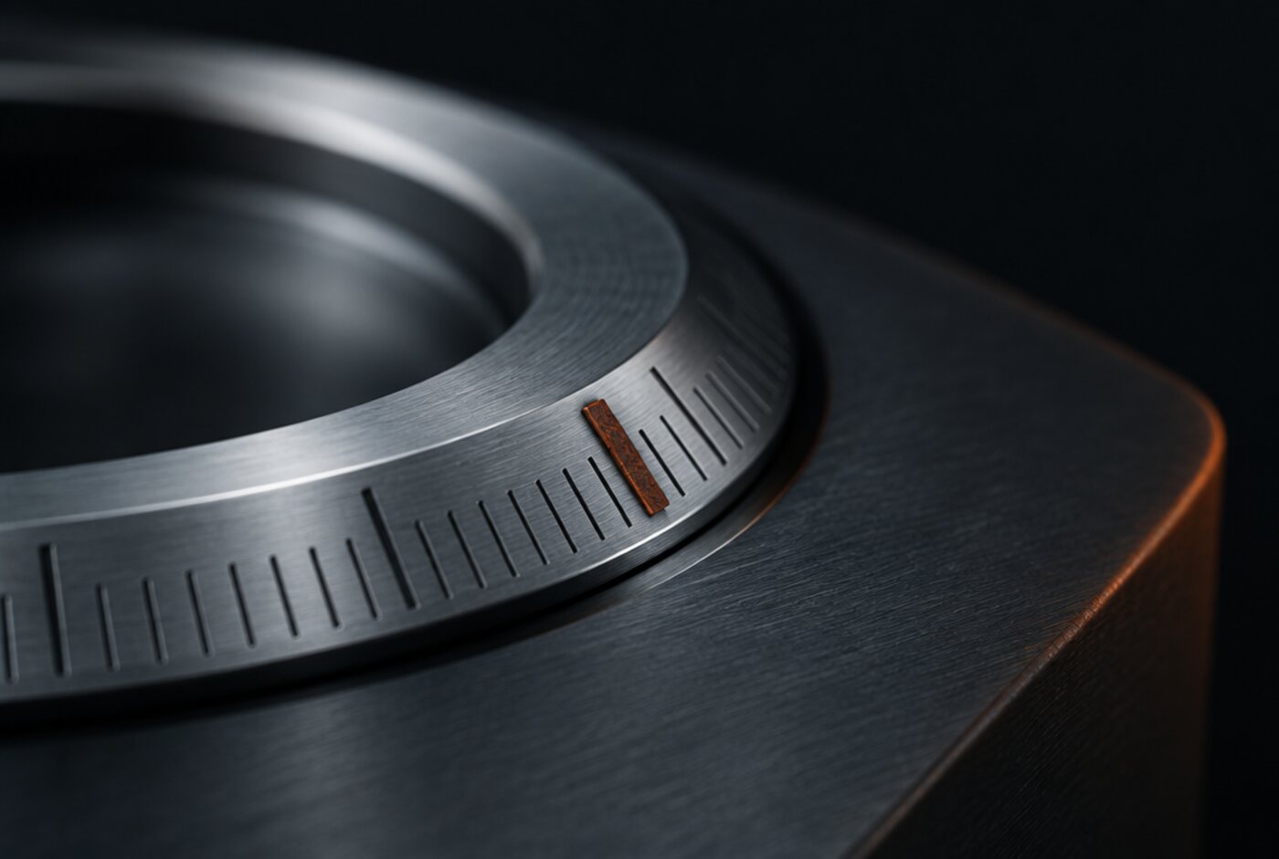Detalle de un dial mecanizado con graduaciones finas y una marca índice en óxido